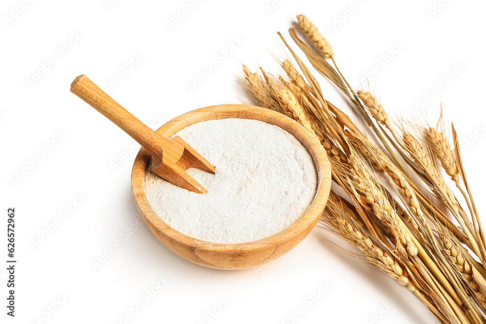 Wooden bowl with flour and wheat ears on white background