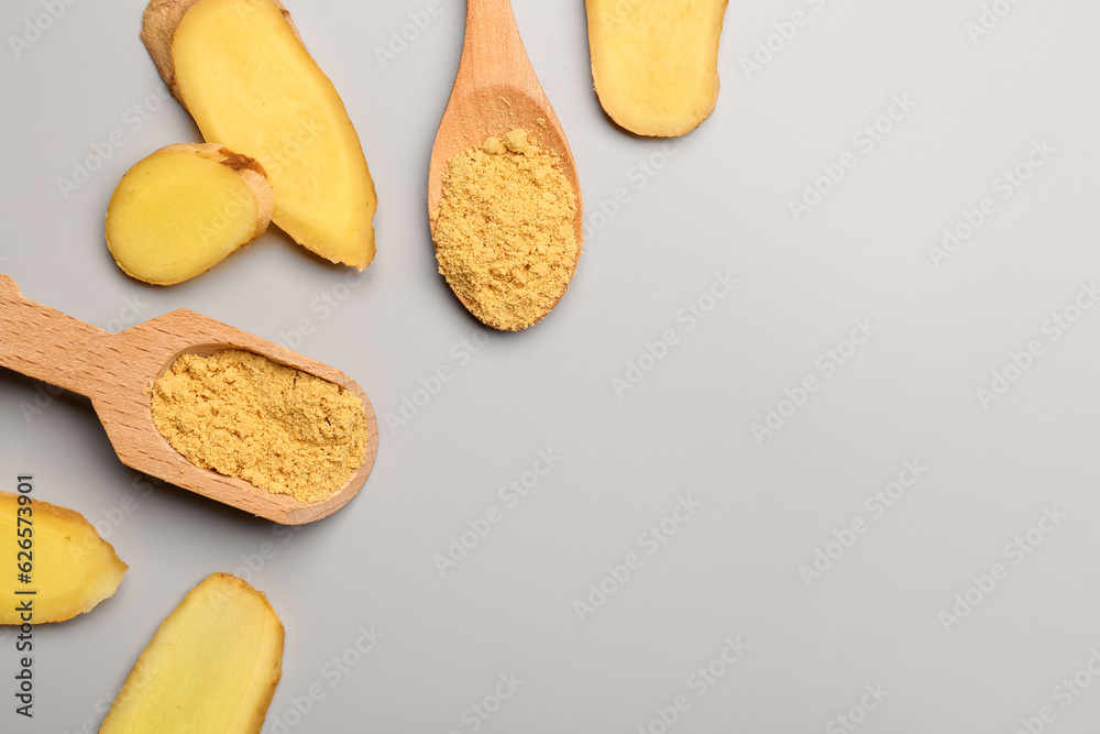 Slices of fresh ginger root, wooden scoop and spoon with dried powder on grey background