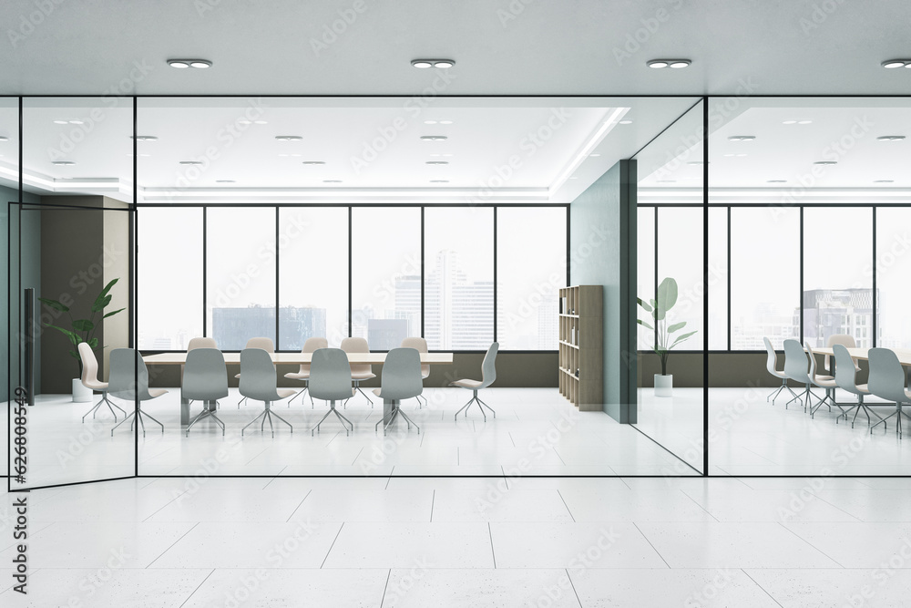 View from hallway to modern meeting room with glass partition, window with city view and grey floor.