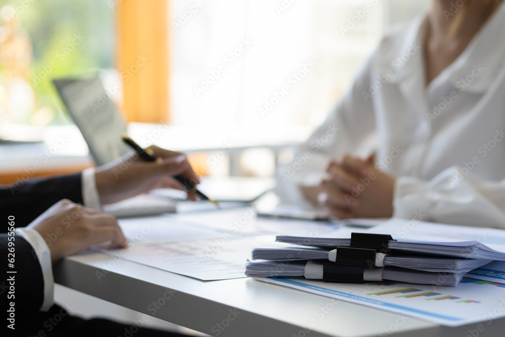 Financial advisor discussing business management planning with businesswoman in office.