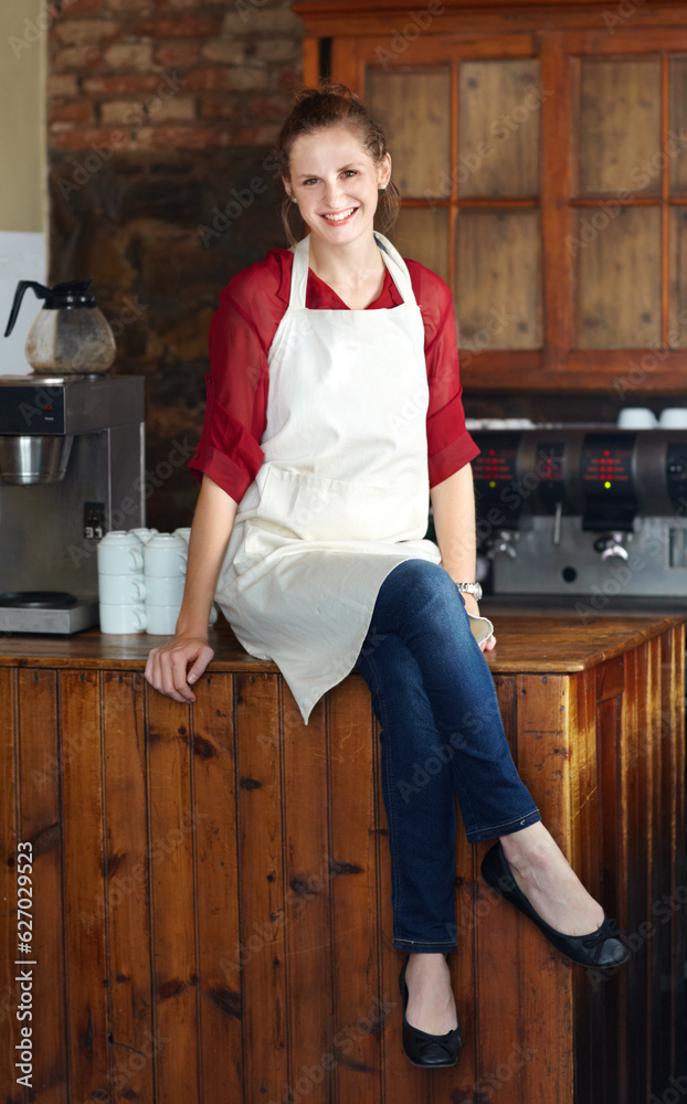 Woman in portrait, barista at coffee shop and sit on countertop, happy employee in hospitality indus