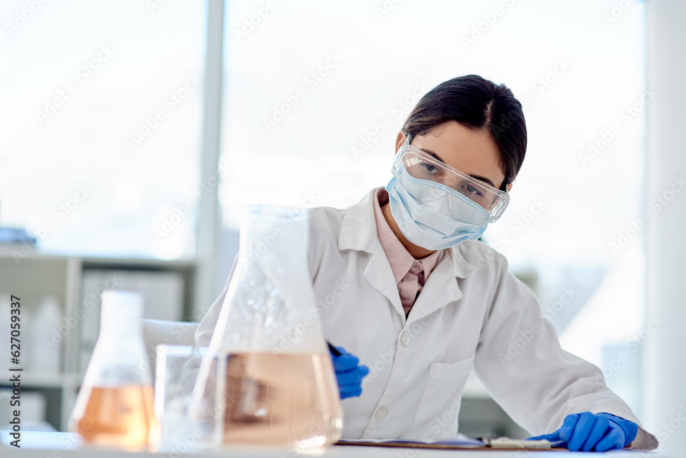 Conducting another careful experiment. Shot of a young scientist doing an experiment in a lab.