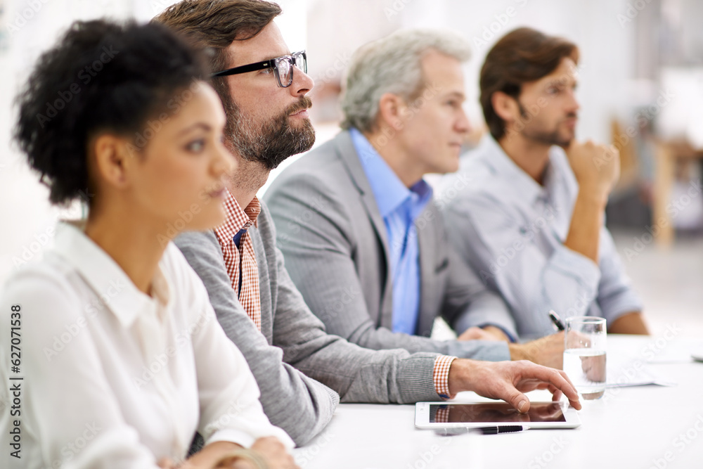 Project debriefing. Shot of a group of dedicated business professionals sitting in a row.