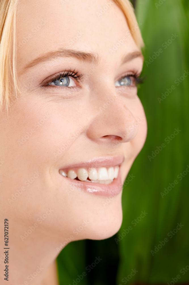 She has such a pure beauty. Headshot of a beautiful young woman against a leafy green background.