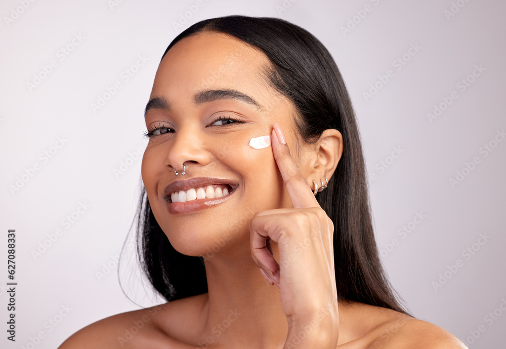 Happy woman, portrait and skincare cream on face for beauty or cosmetics against a grey studio backg