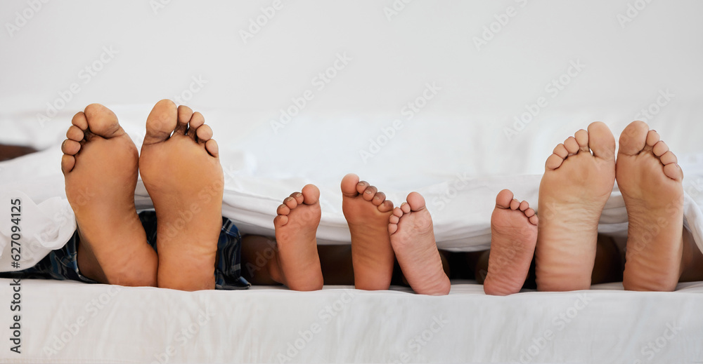 Love, bed and closeup of family feet relaxing, laying and bonding in the bedroom with a blanket. Zoo