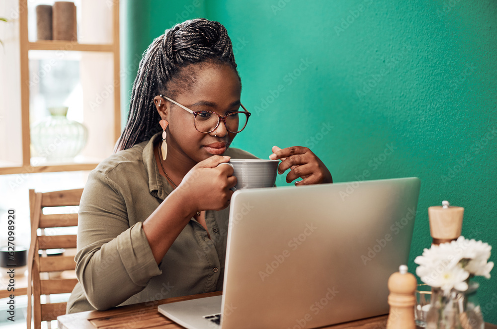 Coffee blogging is kinda her thing. Shot of a young woman having coffee and using a laptop at a cafe