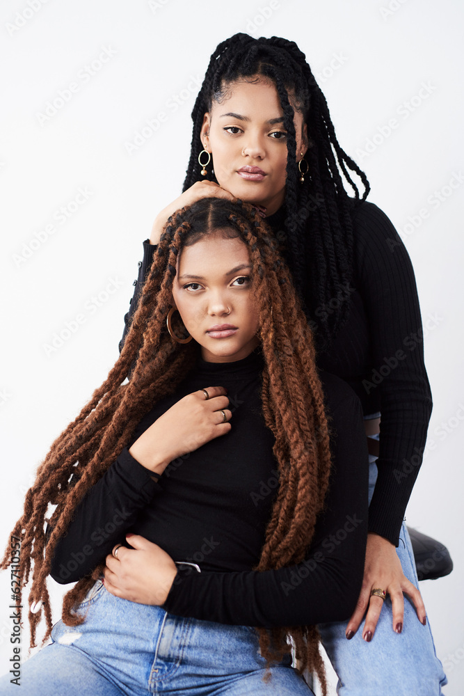 Long natural hair is what they love. Studio shot of two beautiful young women posing against a grey 