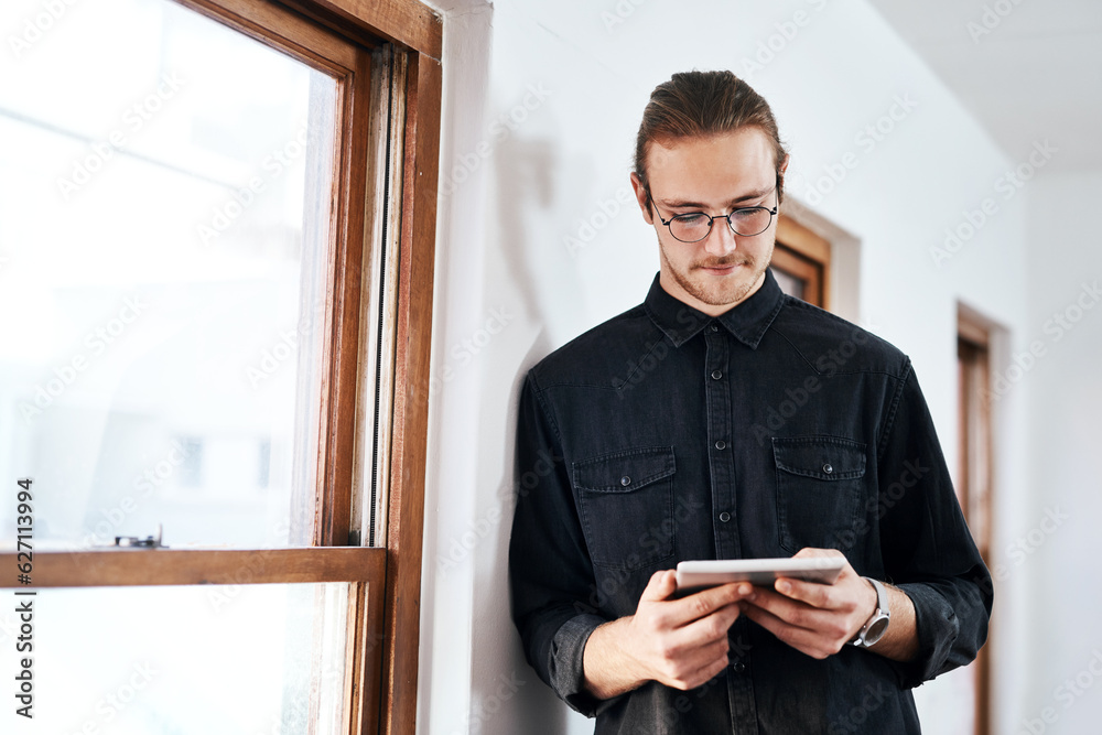 I can achieve anything. Cropped shot of a handsome young businessman standing and using a tablet in 