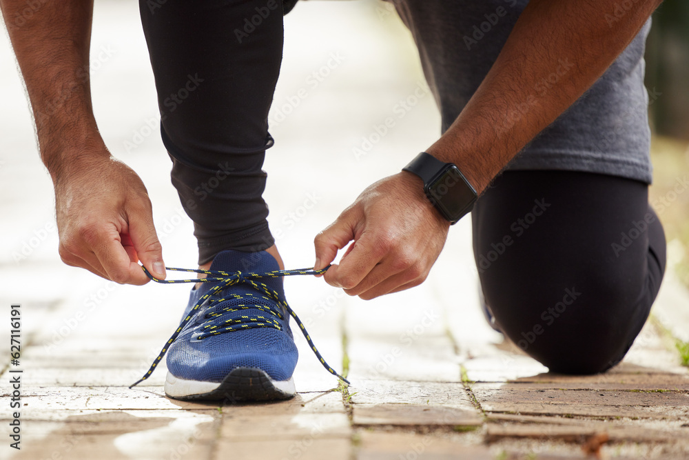 Man, hands and tie shoe in park for running, fitness or cardio workout and exercise in the outdoors.