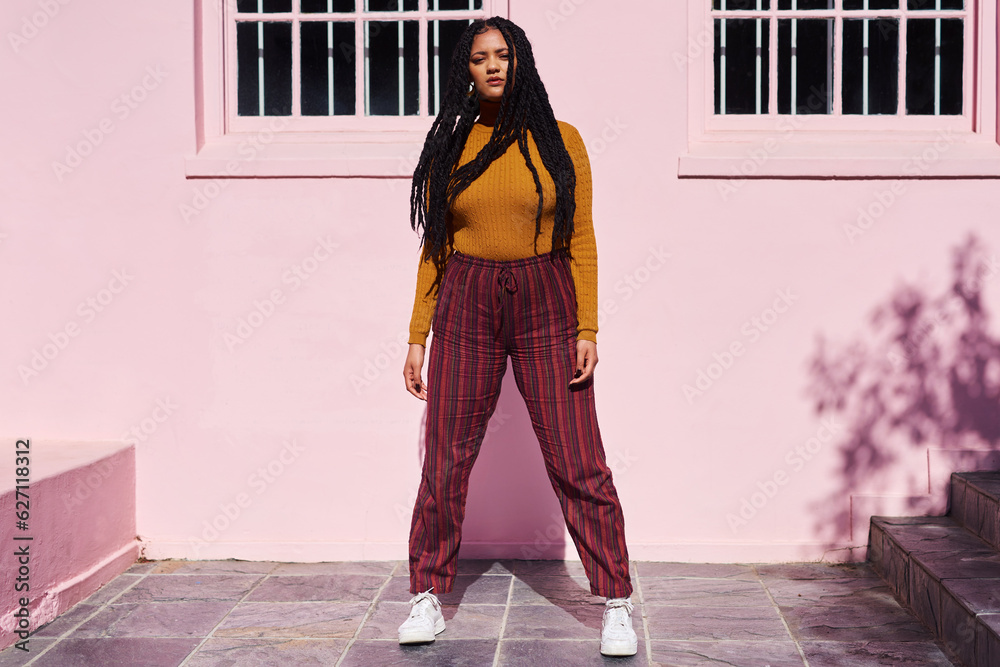 She has style and a whole lotta attitude. Shot of a beautiful young woman posing against a pink wall