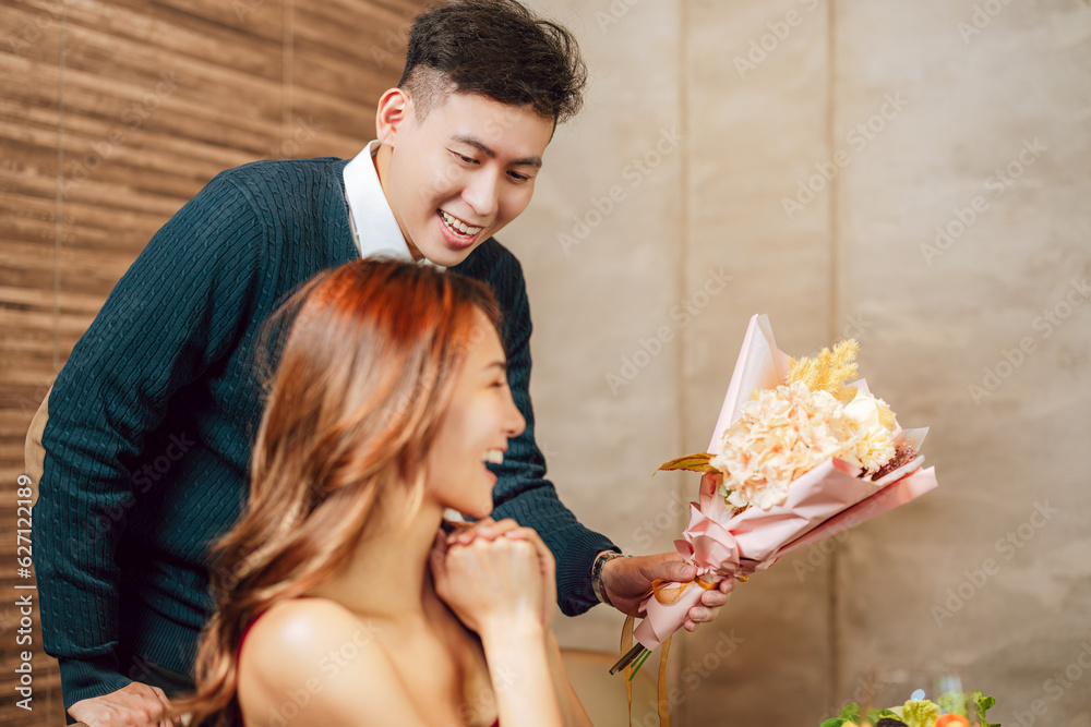 Young man greeting his girlfriend on Valentines Day at restaurant