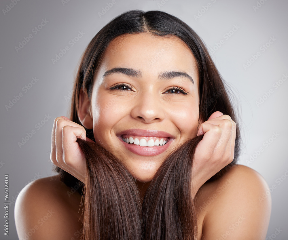 Portrait, beauty and woman with hair care, smile and luxury treatment against a grey studio backgrou