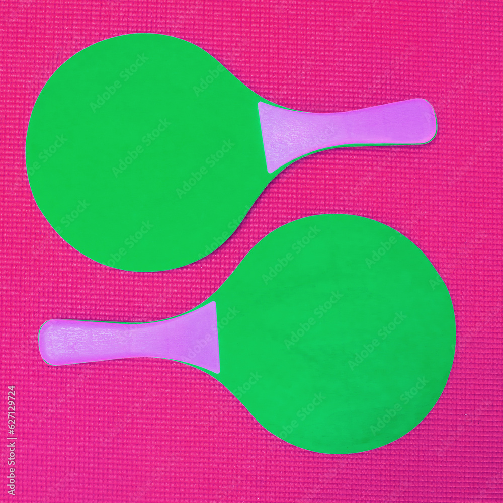 Simple yet a great game to play. High angle shot of two green table tennis rackets placed on top of 