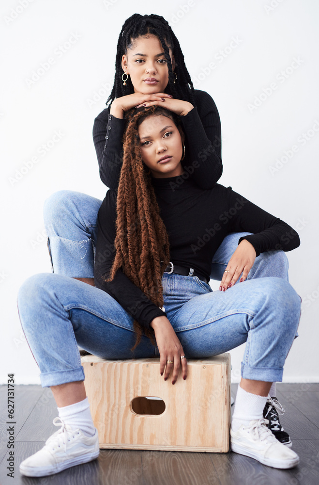 They love being fashionable together. Studio shot of two beautiful young women posing against a grey