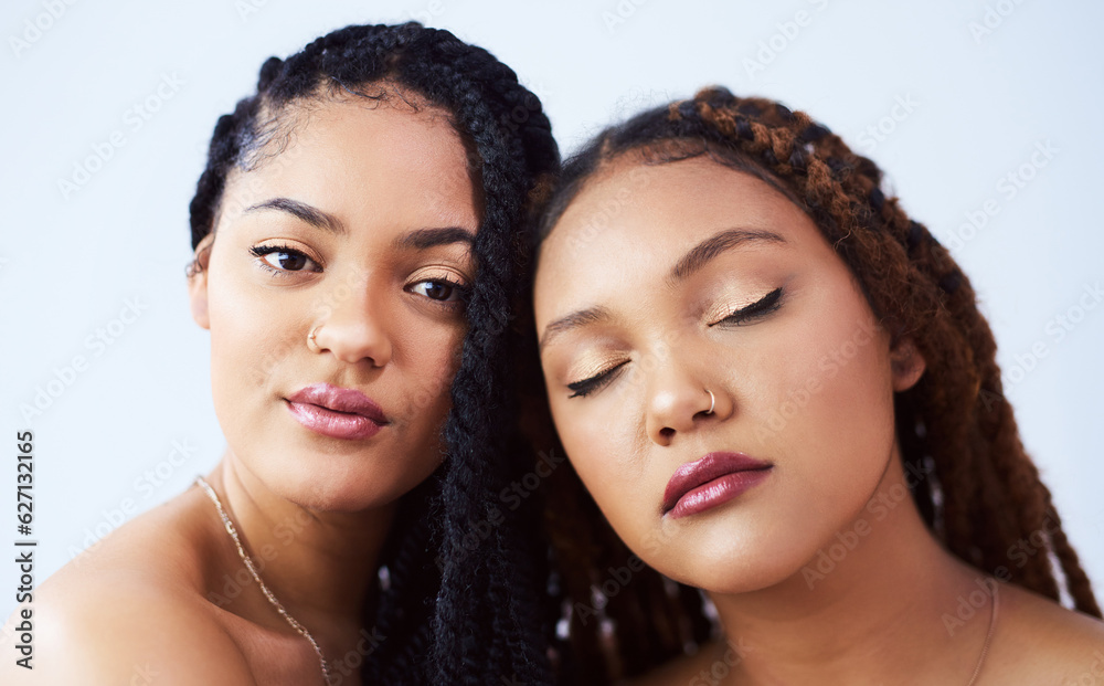 Beautifully brown and glowing. Studio shot of two beautiful young women posing against a grey backgr