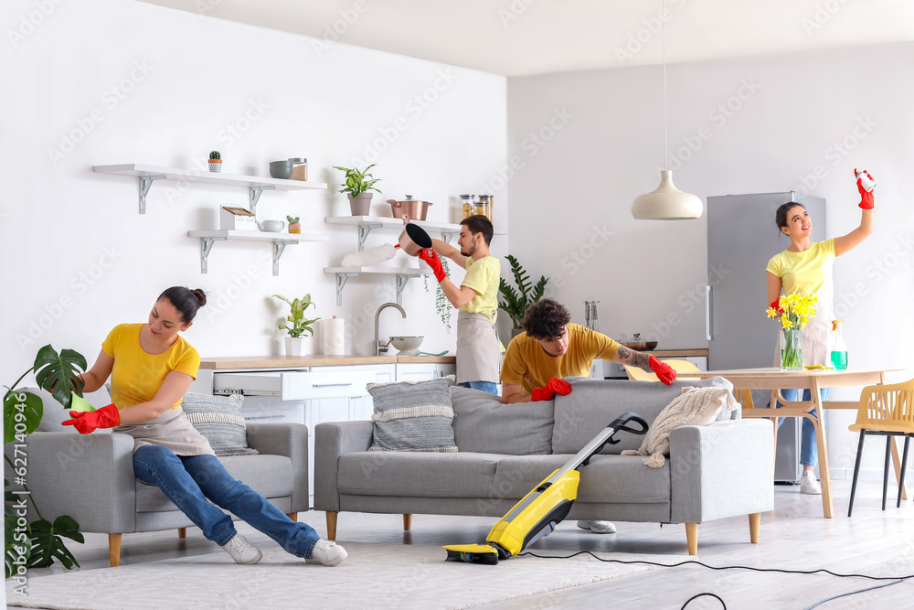 Young janitors cleaning in kitchen