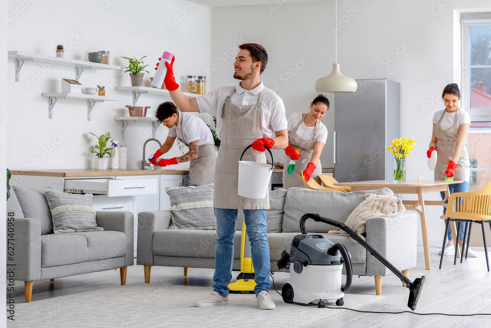 Young janitors cleaning in kitchen