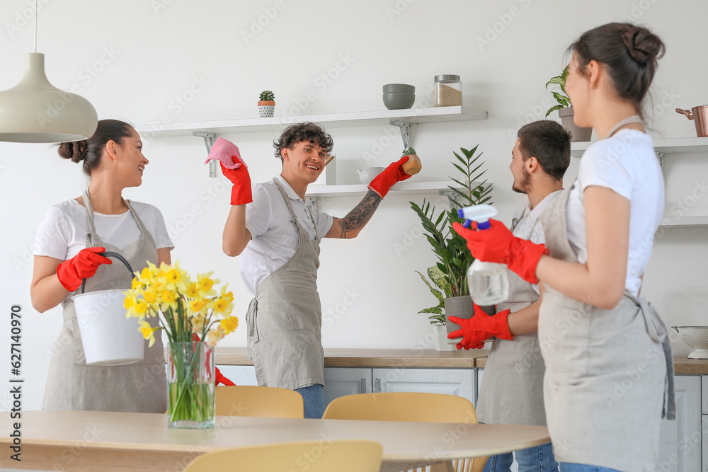 Young janitors cleaning in kitchen