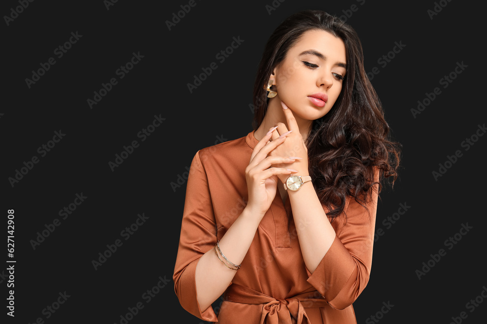 Elegant beautiful woman with wristwatch on black background