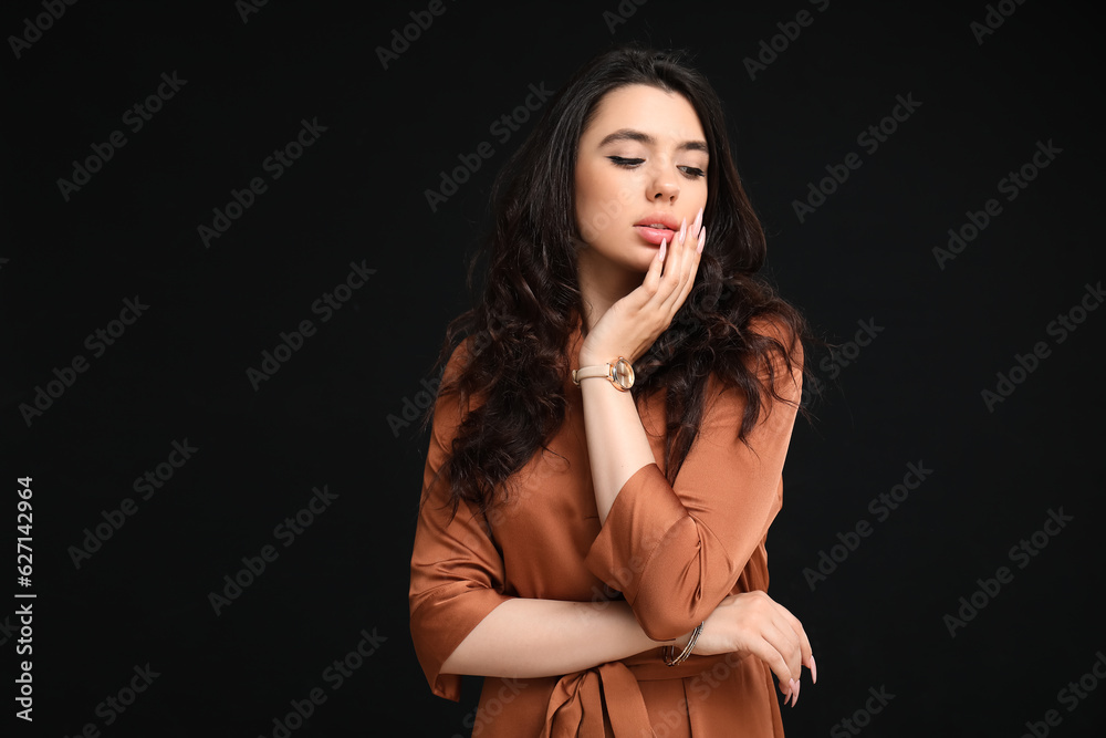 Elegant beautiful woman with wristwatch on black background