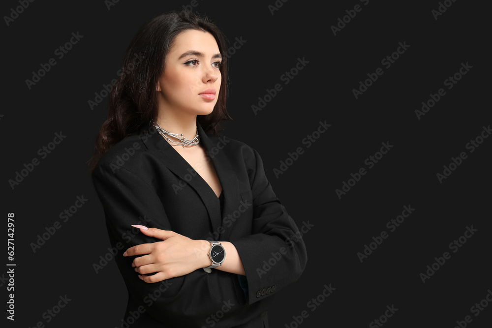 Beautiful young woman with wristwatch on black background