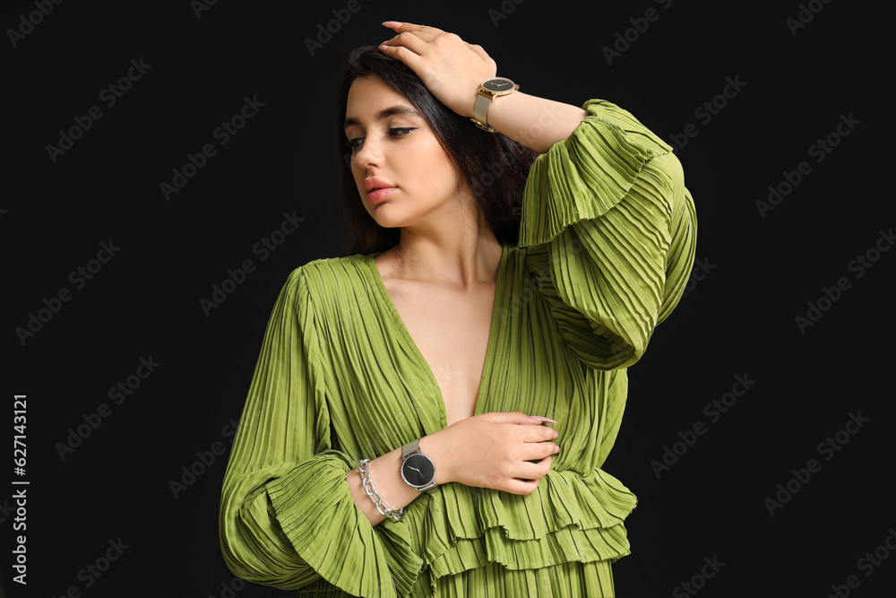 Beautiful young woman with wristwatches on black background