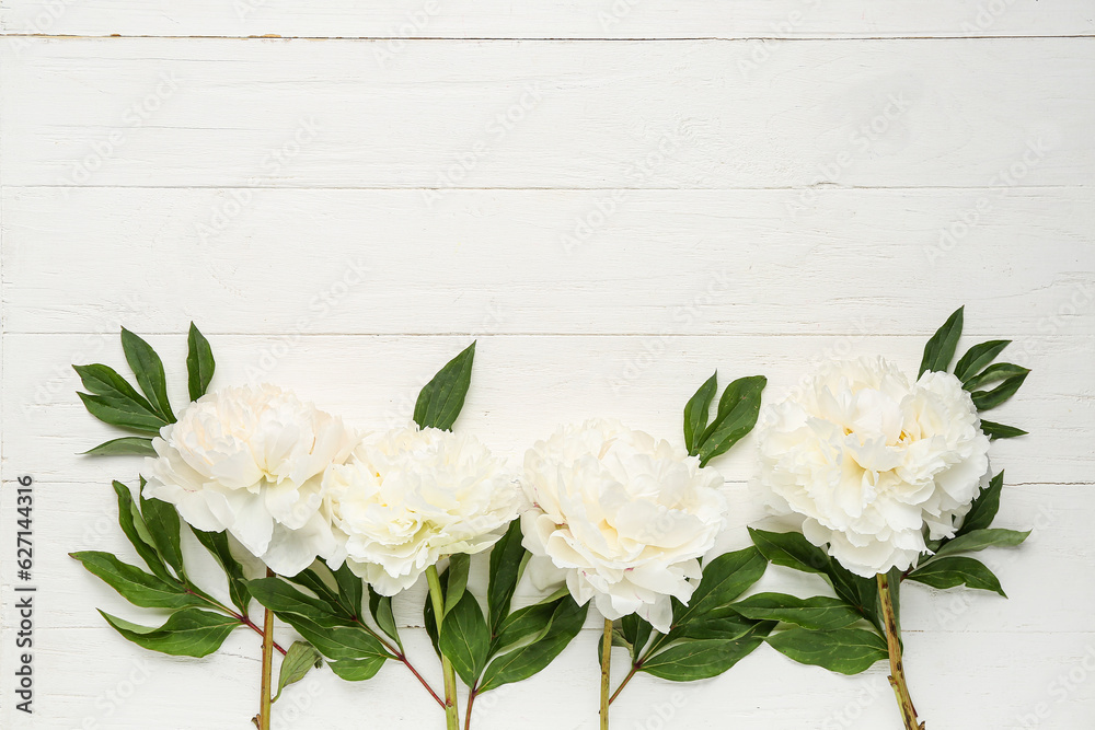 Composition with beautiful peony flowers on light wooden background