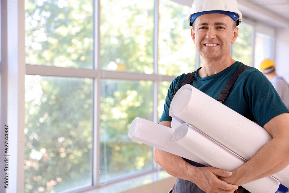 Mature builder with paper rolls in room