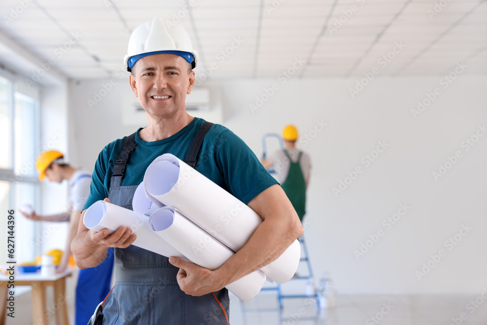 Mature builder with paper rolls in room