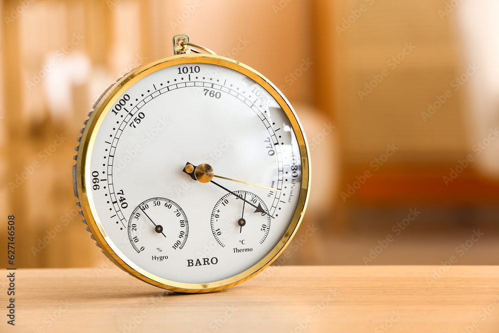 Aneroid barometer on wooden table in room, closeup