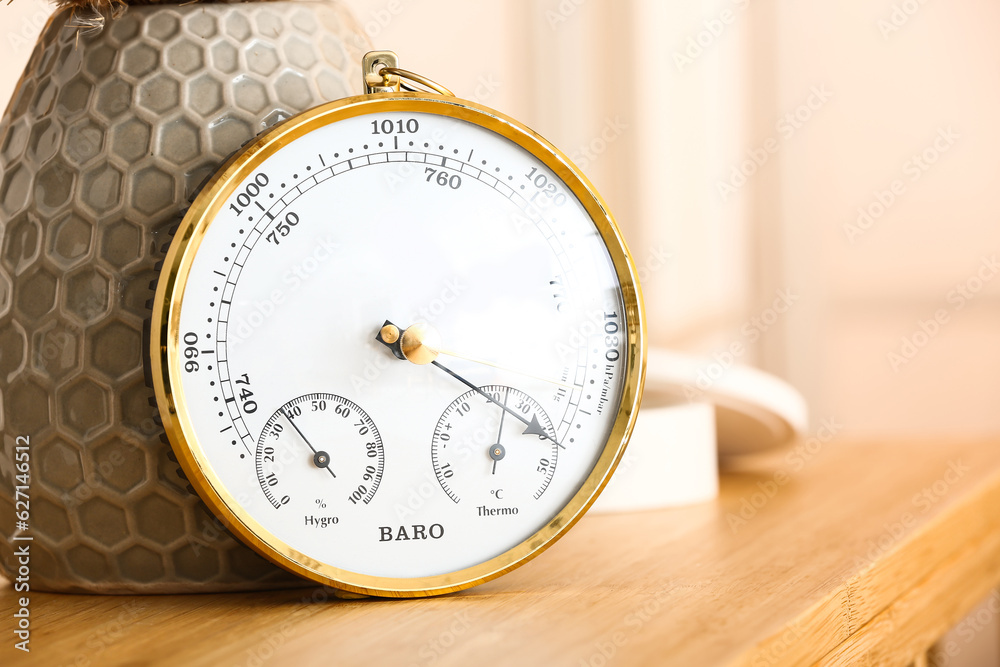 Aneroid barometer on wooden table in room, closeup