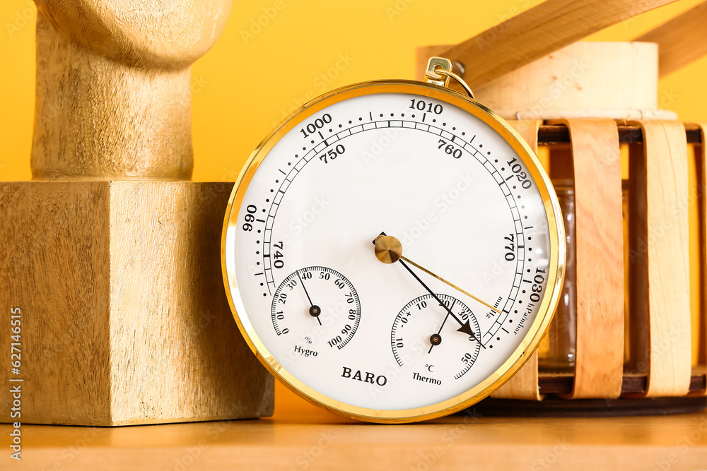 Aneroid barometer on wooden table in room, closeup