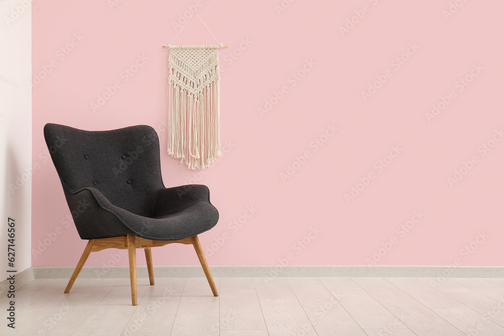 Grey armchair near pink wall