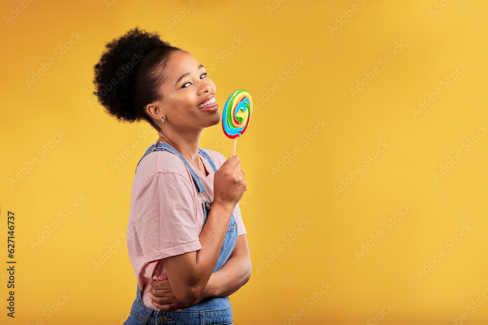 Black woman, portrait and eating candy or lollipop in studio on yellow background and sweets, desser