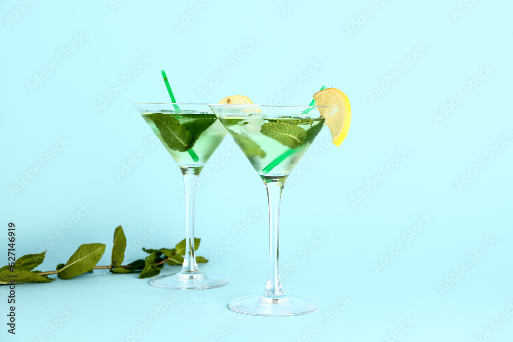 Glasses of tasty mojito on color background