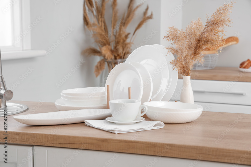 Set of clean dishes on wooden countertop in kitchen, closeup