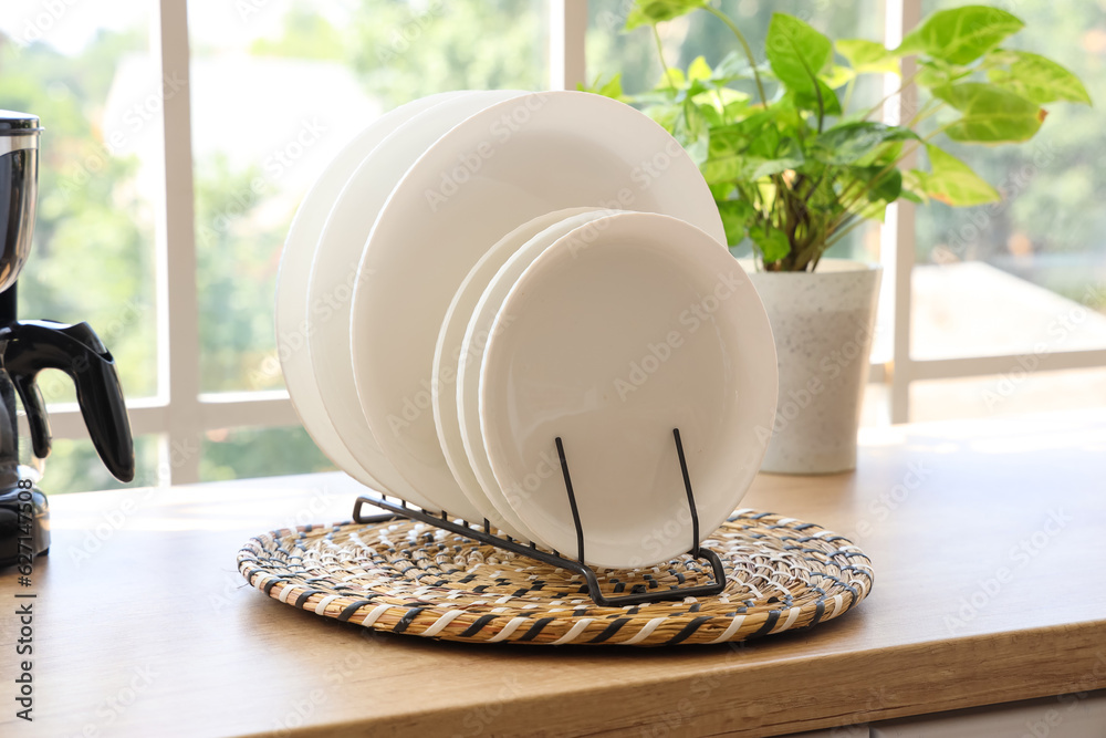 Wicker mat with plate rack on wooden countertop, closeup