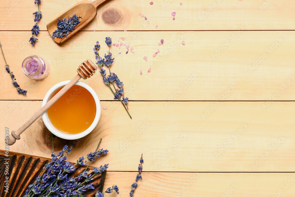 Bowl of sweet lavender honey, dipper and flowers on wooden background