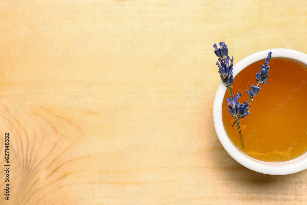 Bowl of sweet lavender honey on wooden background