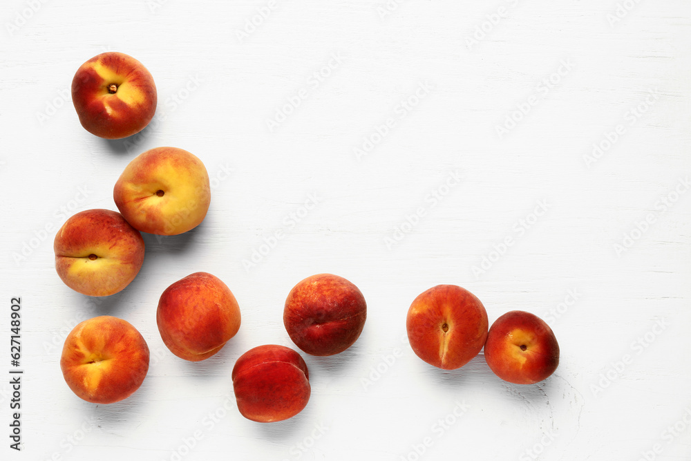 Many sweet peaches on white wooden background