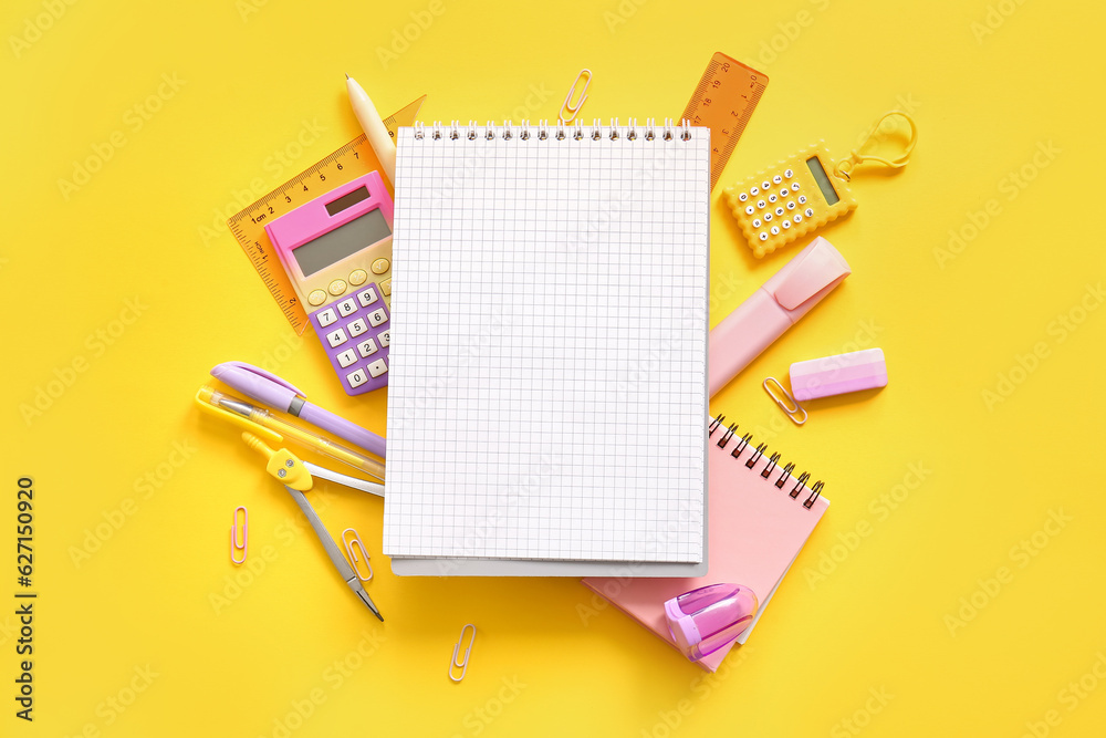 Composition with blank notebook and school stationery on yellow background