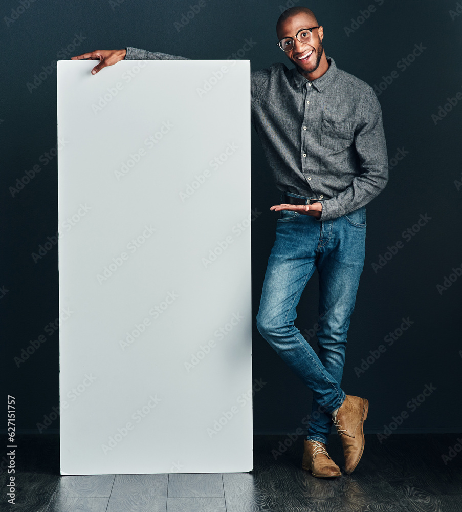 Are you interested. Shot of a handsome young man standing next to a blank placard.