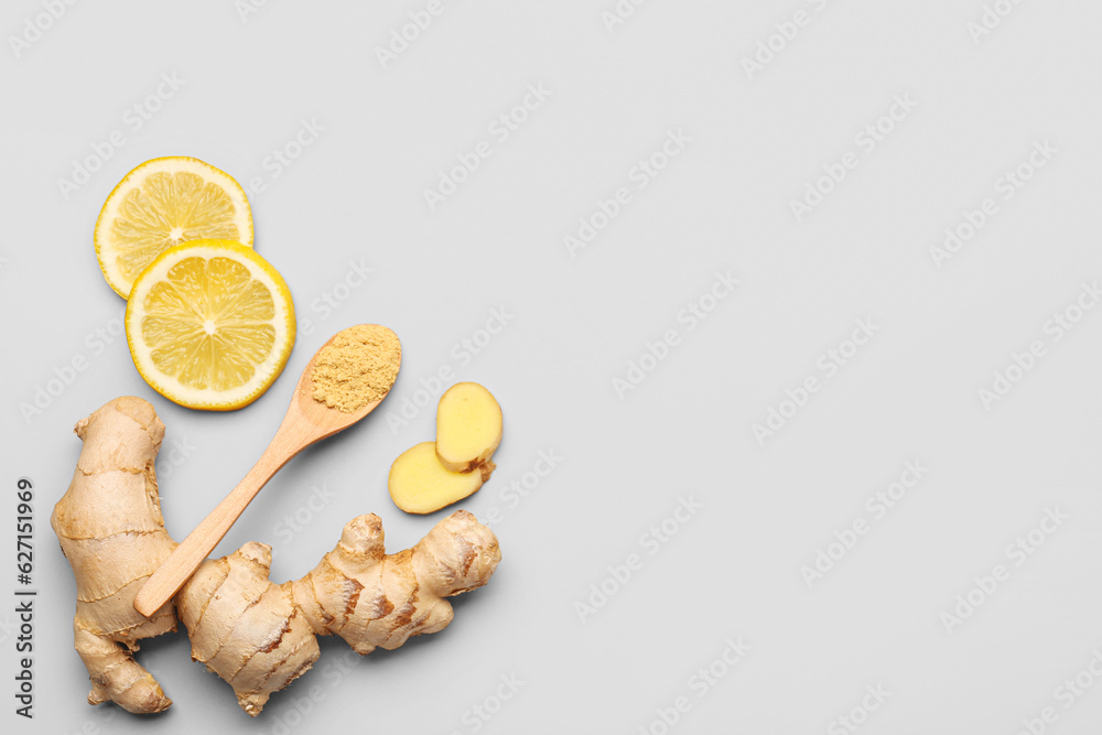 Fresh ginger root, slices of lemon and wooden spoon with dried powder on grey background