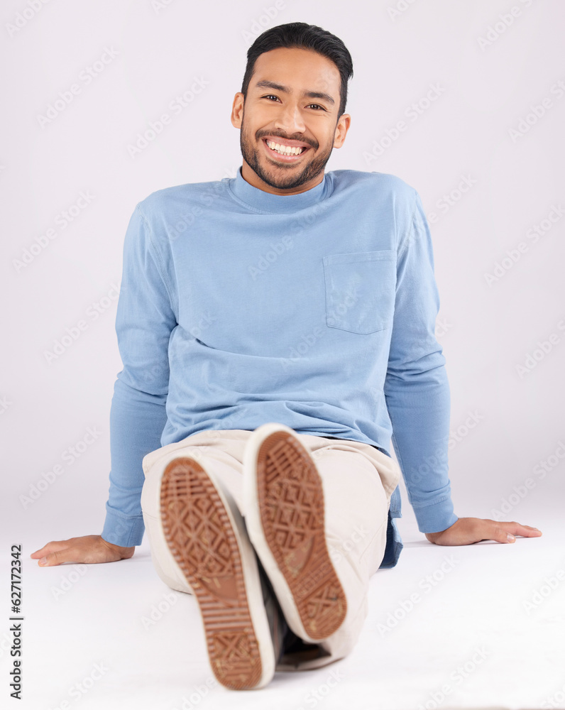 Portrait, fashion and man smile on the floor in studio isolated on a white background. Style, happy 