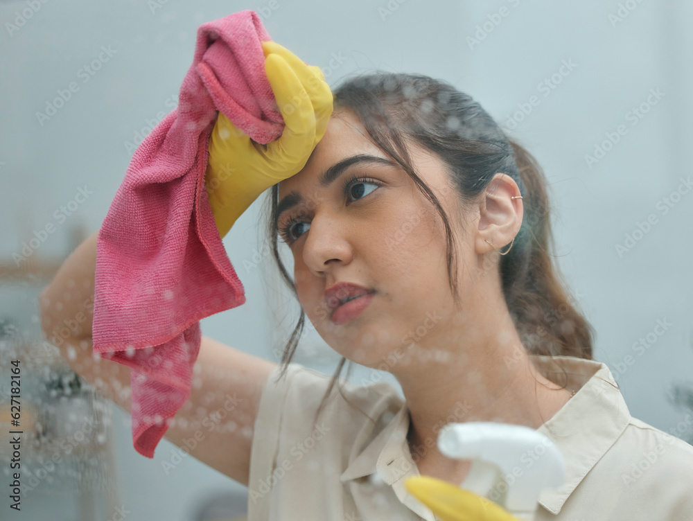 Cleaning, window and a woman housekeeper sweating while in a home to wash glass as a routine chore. 