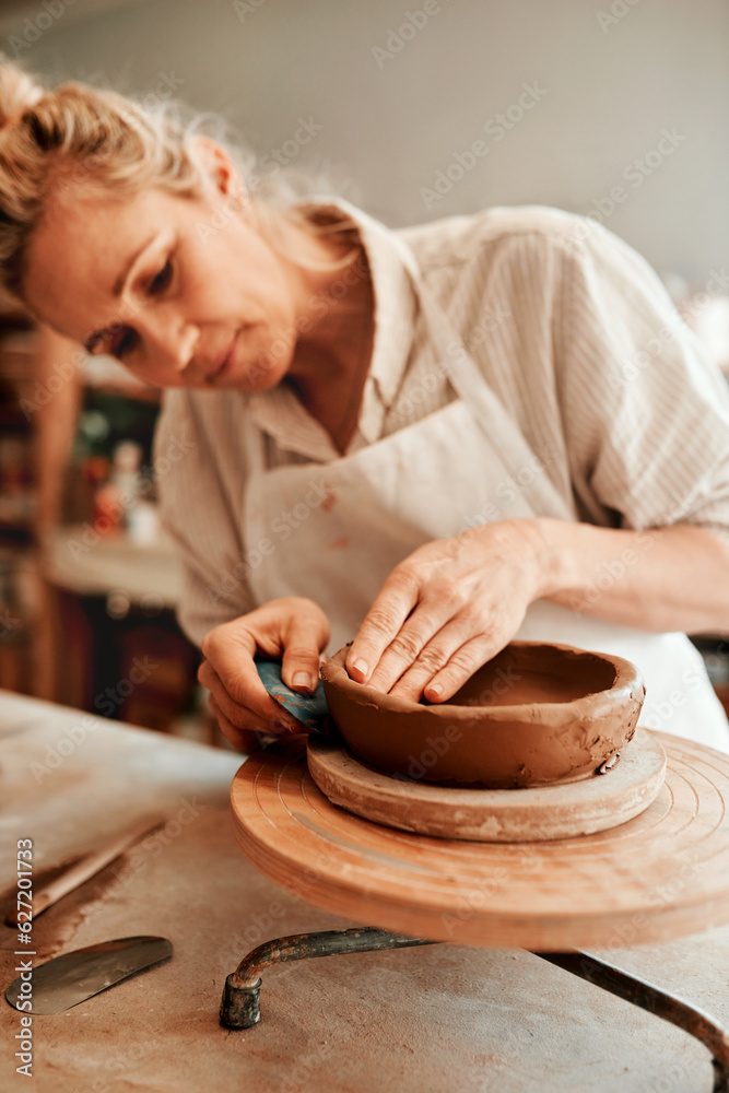 I love working with clay. Cropped shot of a woman shaping a clay pot in her workshop.