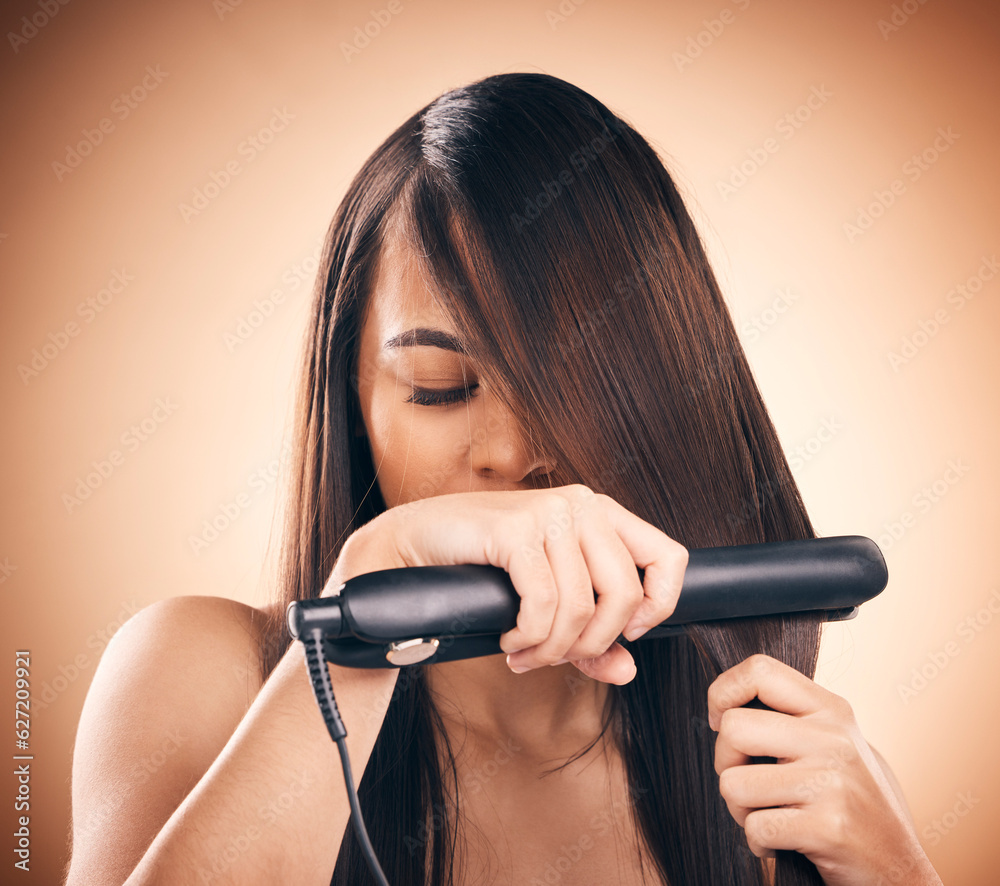 Young woman, hair care and flat iron in studio to straightener for healthy shine and growth. Young f