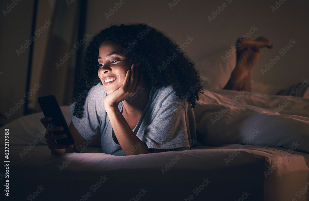 Happy woman, phone and relax in bed at night for social media, online browsing or streaming at home.