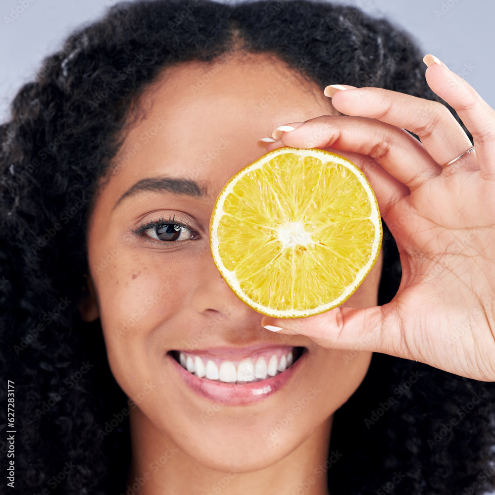 Portrait, wellness and woman with lemon eye for nutrition in closeup in grey studio background. Skin